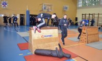 Policjant przeskakujący skrzynię podczas konkurencji sportowej
